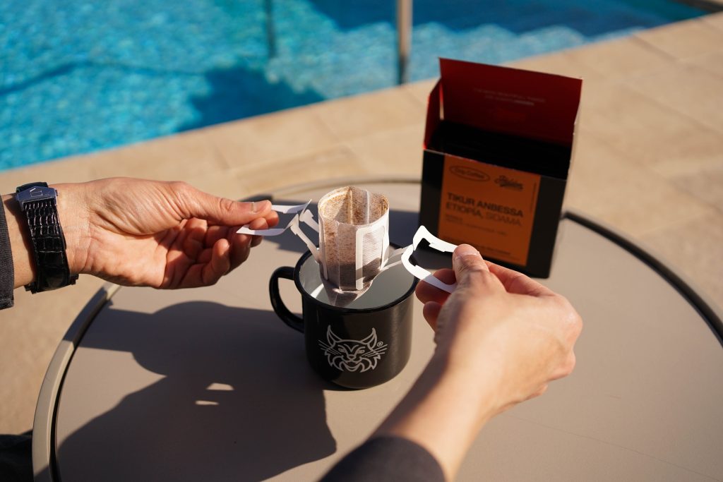 Pack Drip&Trip de Hidden Coffee Roasters. Caja con 8 sobres monodosis de café de especialidad preparado para drip coffee. Filtro de asas que se coloca encima de la cualquier taza.